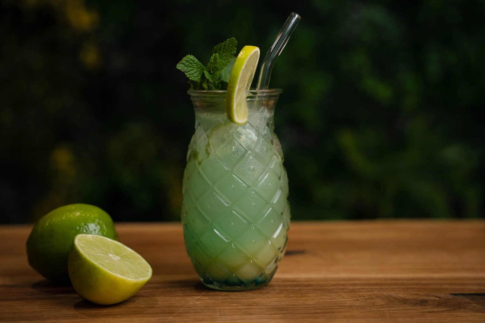 Mocktail mit Limette und frischer Minze auf einem Holztisch